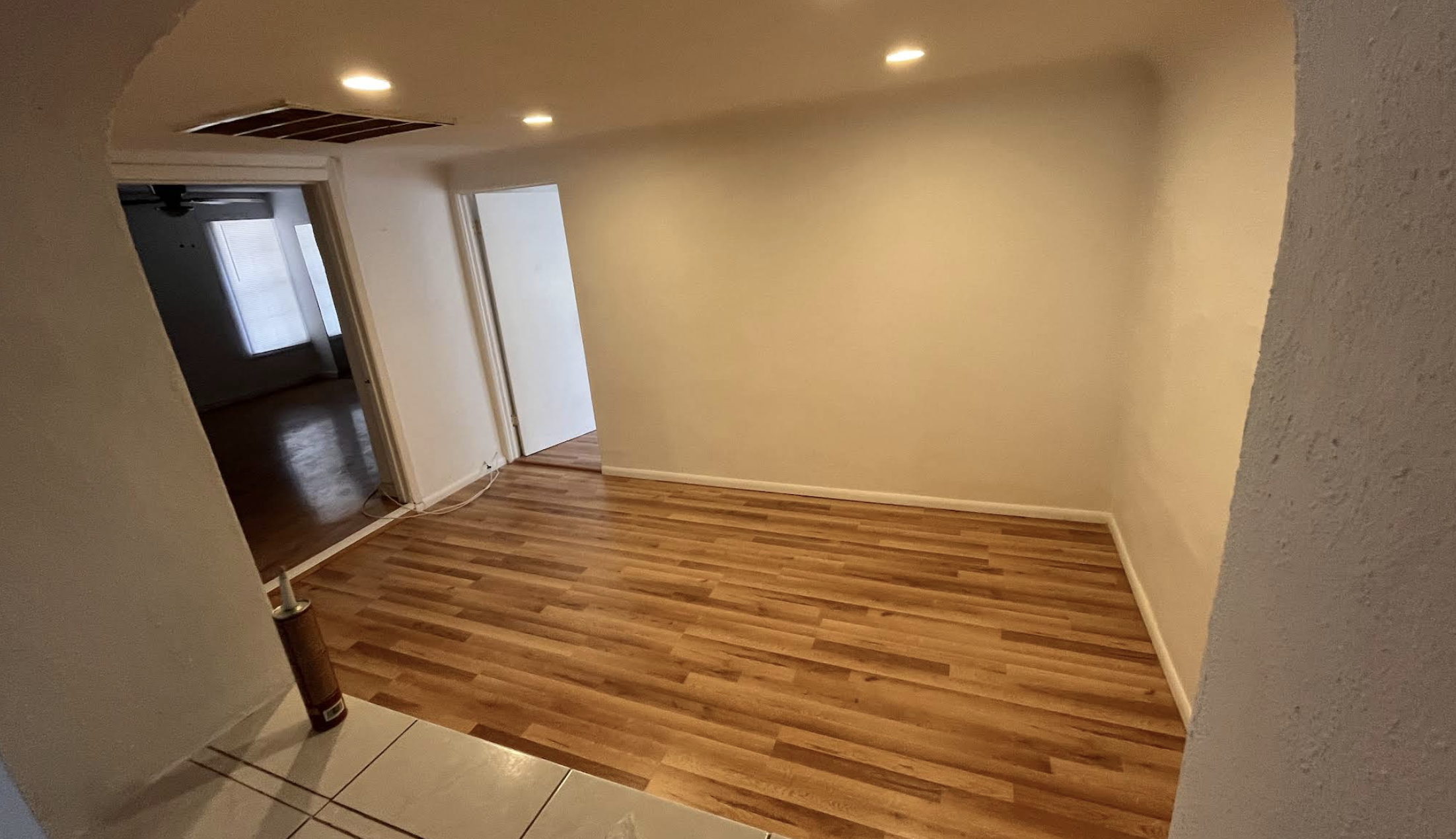 Living area with hardwood floor and archway